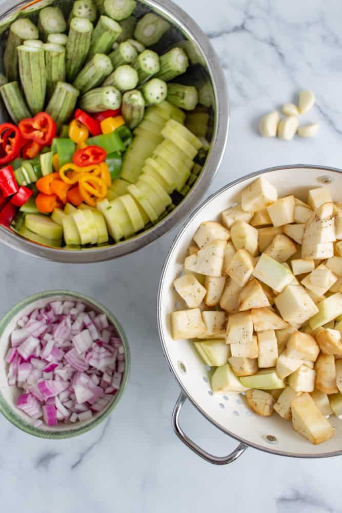 Mediterranean vegetable stew ingredients: chopped eggplants, onions, zucchini, and okra.