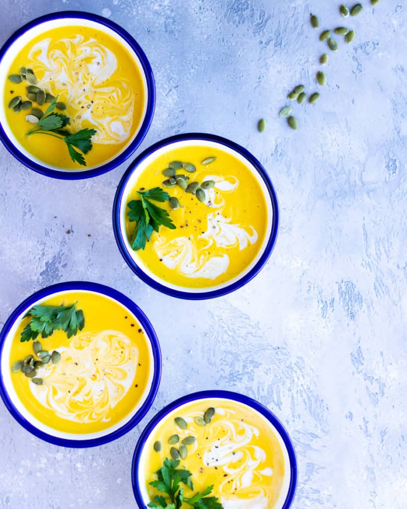 butternut squash soup in bowls on blue background