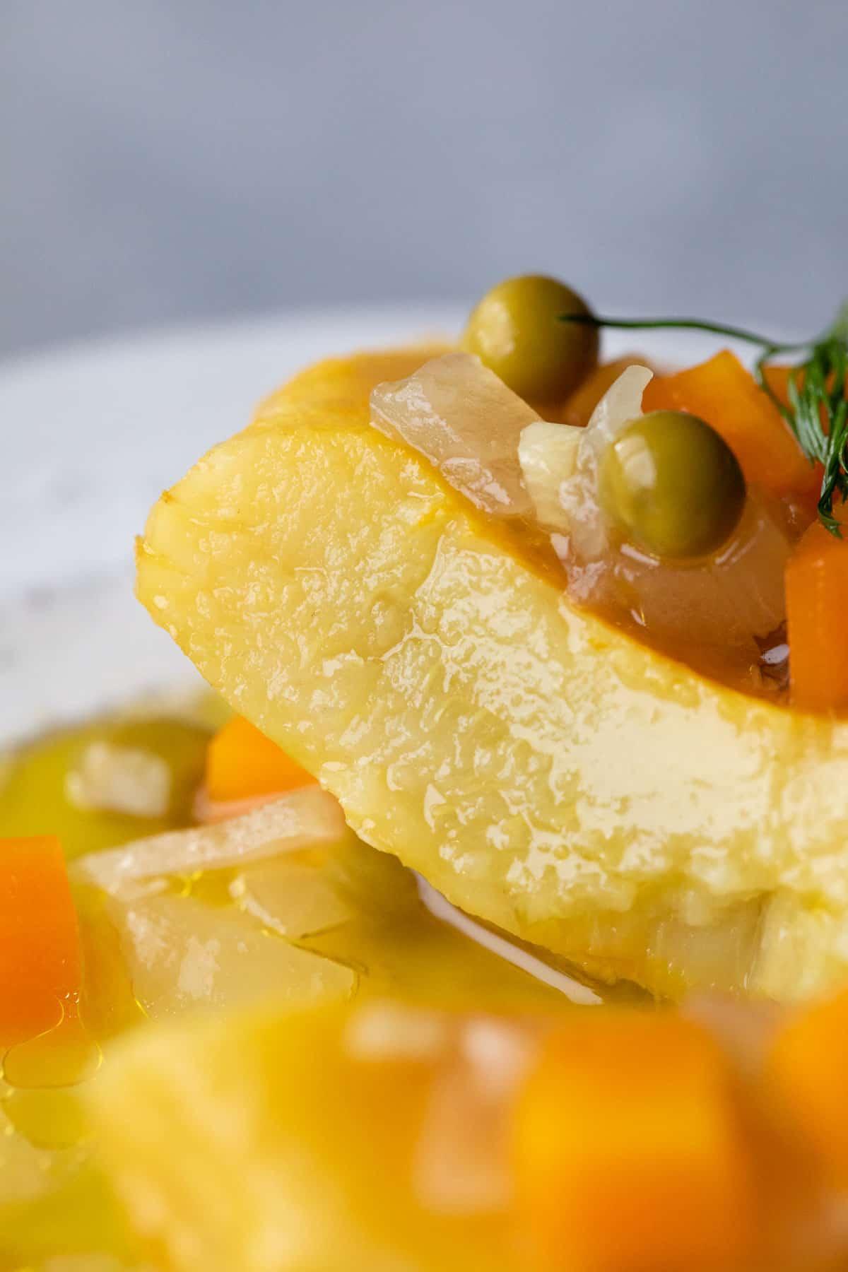 tender artichoke heart on a plate with peas and carrots