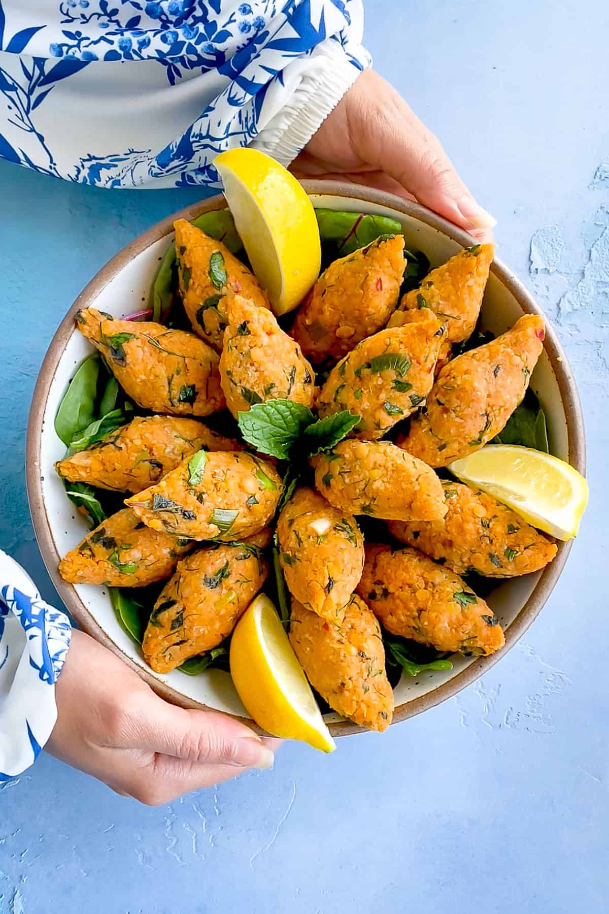 Turkish Lentil Balls on a plate, held by a woman