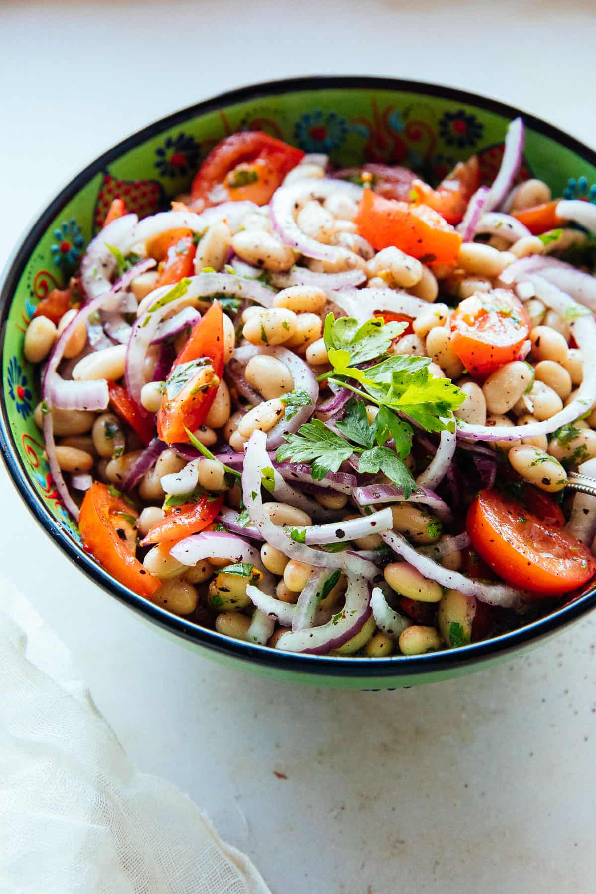 Mediterranean Bean Salad backlit in a bowl