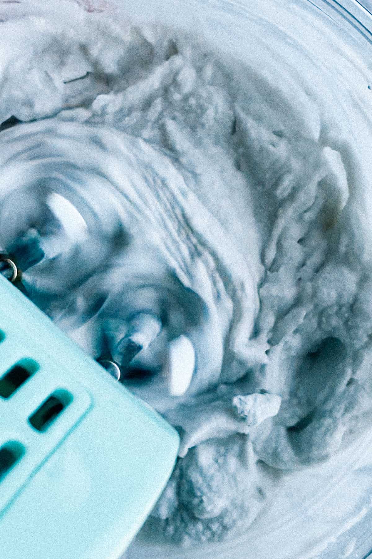 whipping coconut cream with electric whisk in a bowl