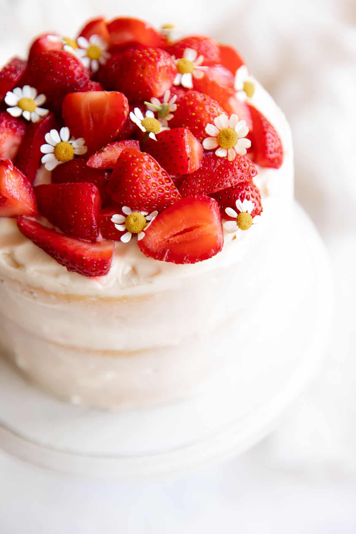 cake decorated with strawberries and chamomile