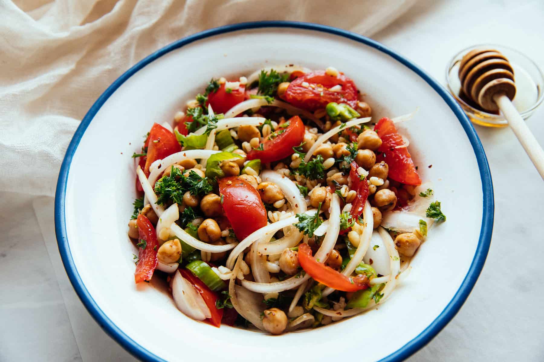 spicy chickpea and bulgur salad in a bowl with pomegranate molasses on the side