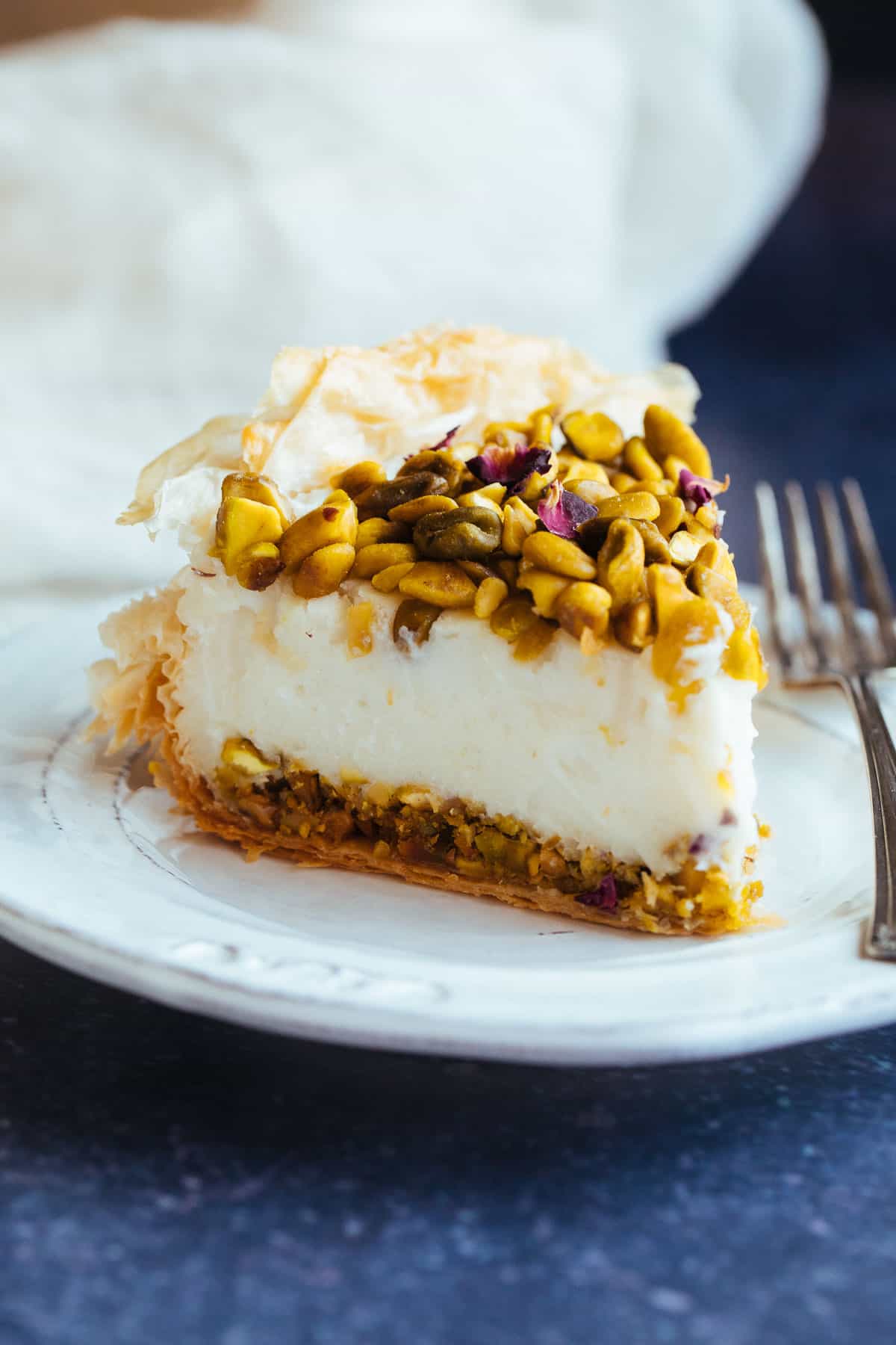 vegan baklava cheesecake slice on a white plate