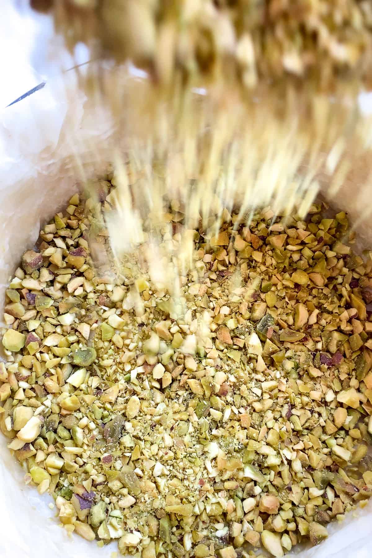 pistachio meat being poured into cheesecake pan