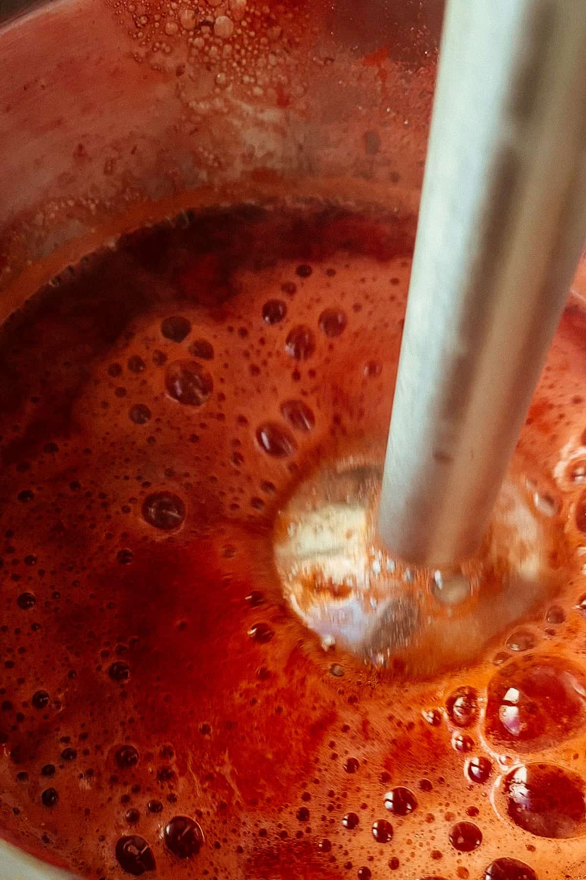 blending strawberries with an immersion blender