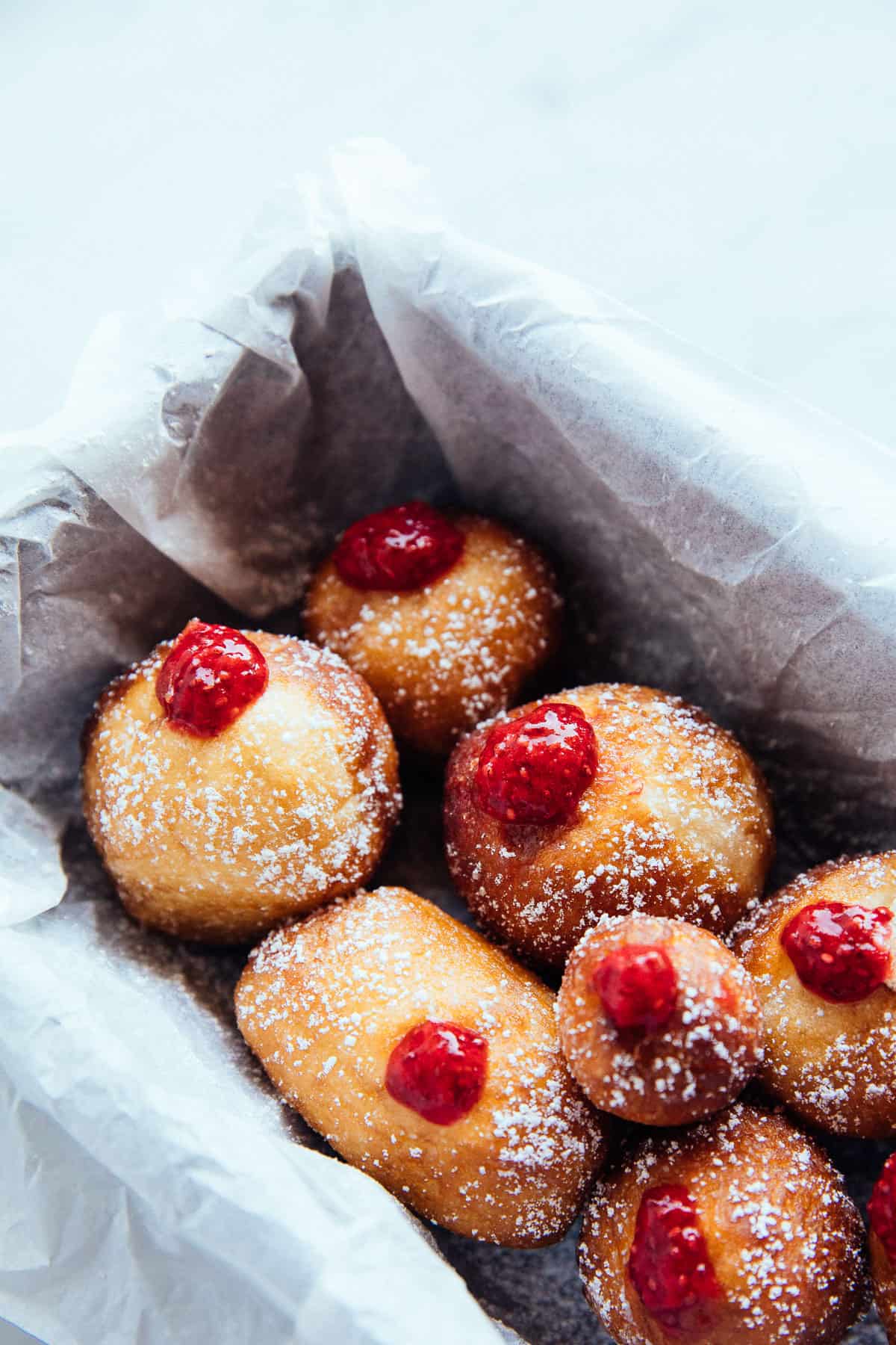 vegan jelly doughnuts in a tray with dusted sugar