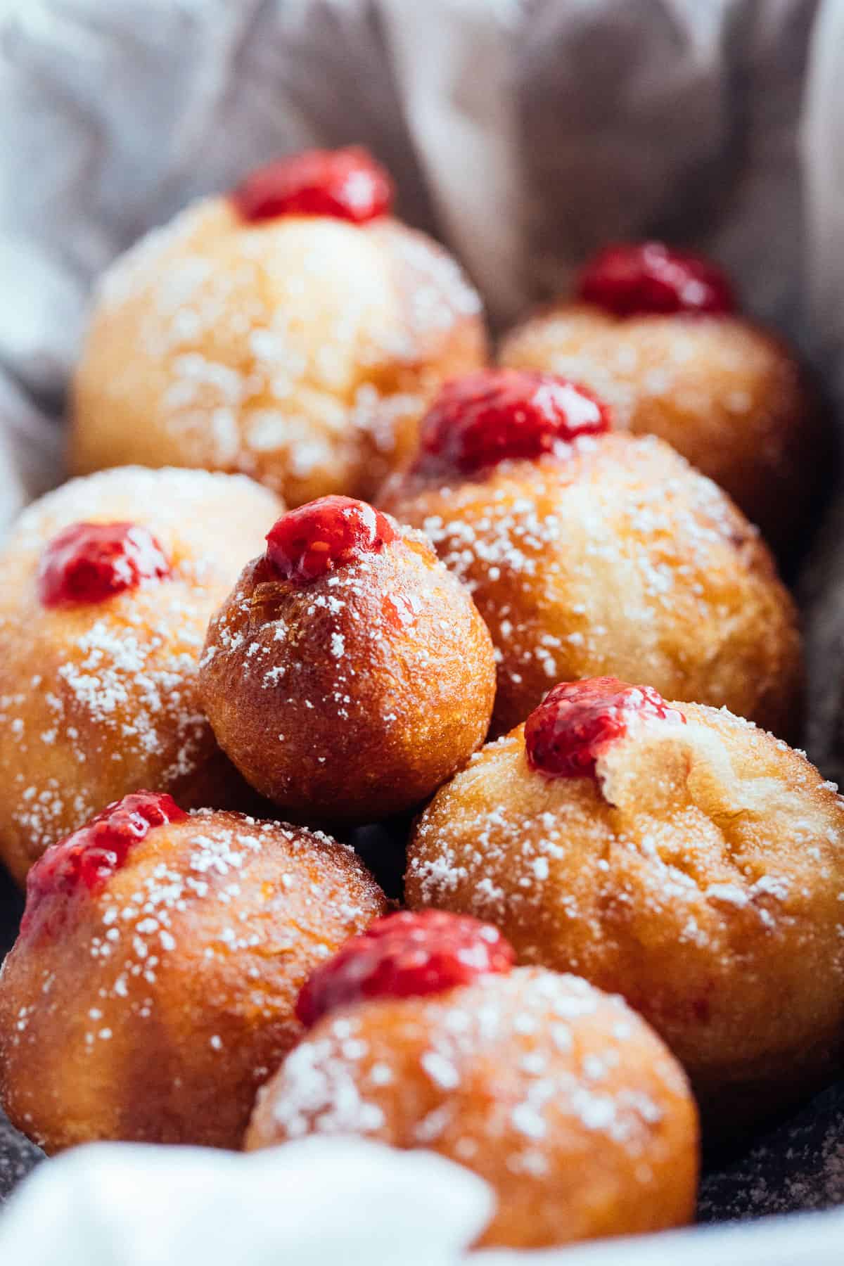 backlit vegan jelly doughnuts in a tray dusted with sugar
