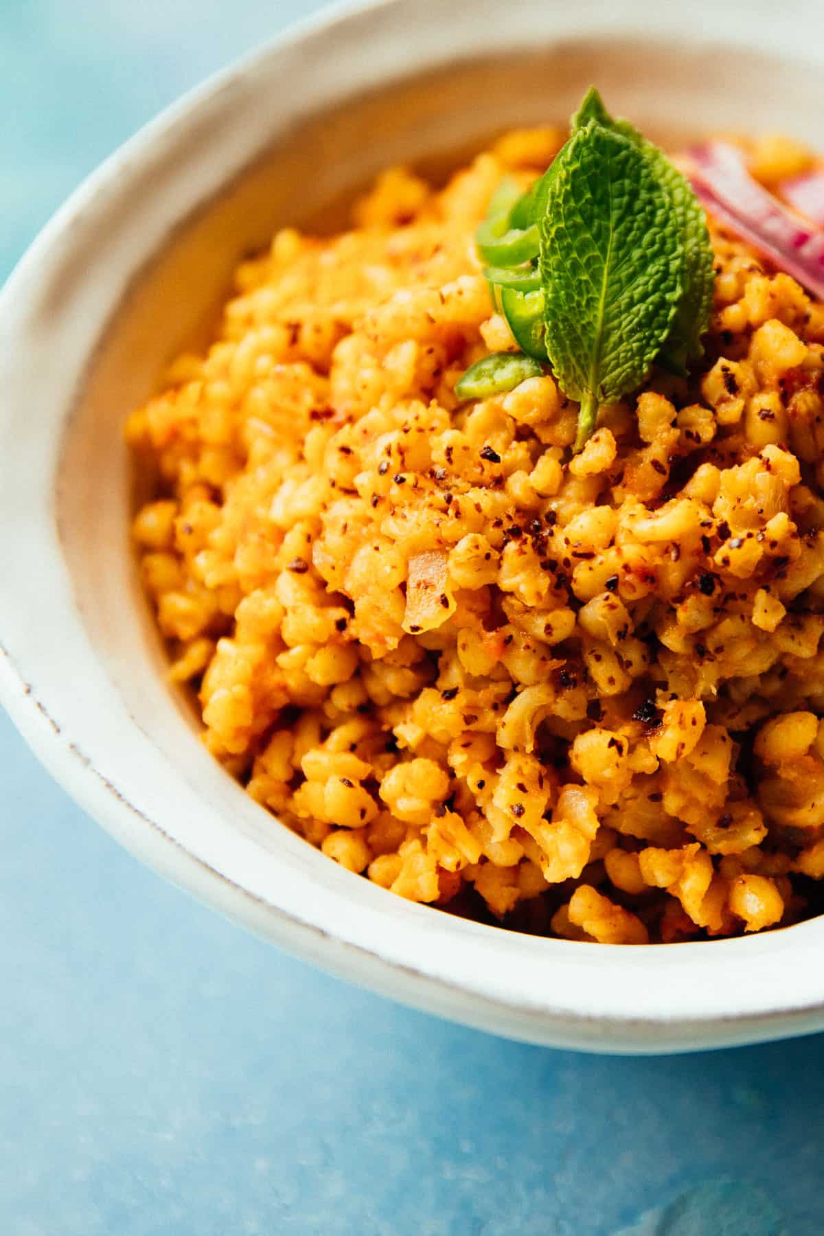 tomato bulgur pilaf with mint leaves and Aleppo pepper