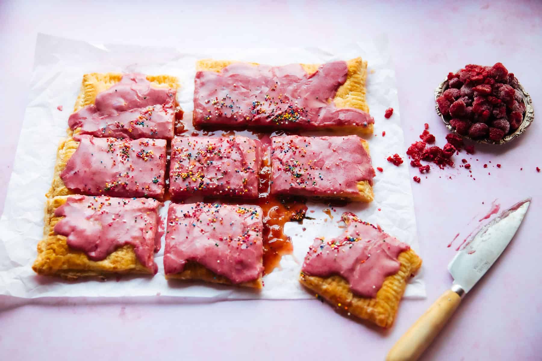 giant strawberry pop tart sliced on parchment paper